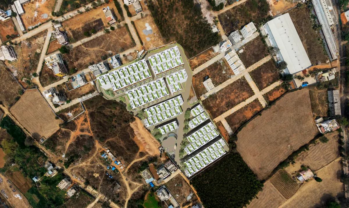 Aerial view over the Aiikya Forestscape masterplan — low-rise blocks threaded with green